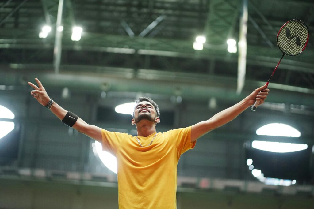 pexels photo 29873466 29873466 A badminton player in a yellow shirt celebrates triumphantly in an indoor stadium.